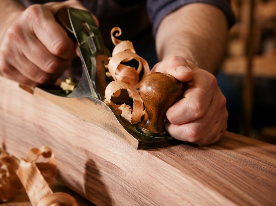 A hand plane shaping solid walnut in the Mobile Coffee Cart workshop